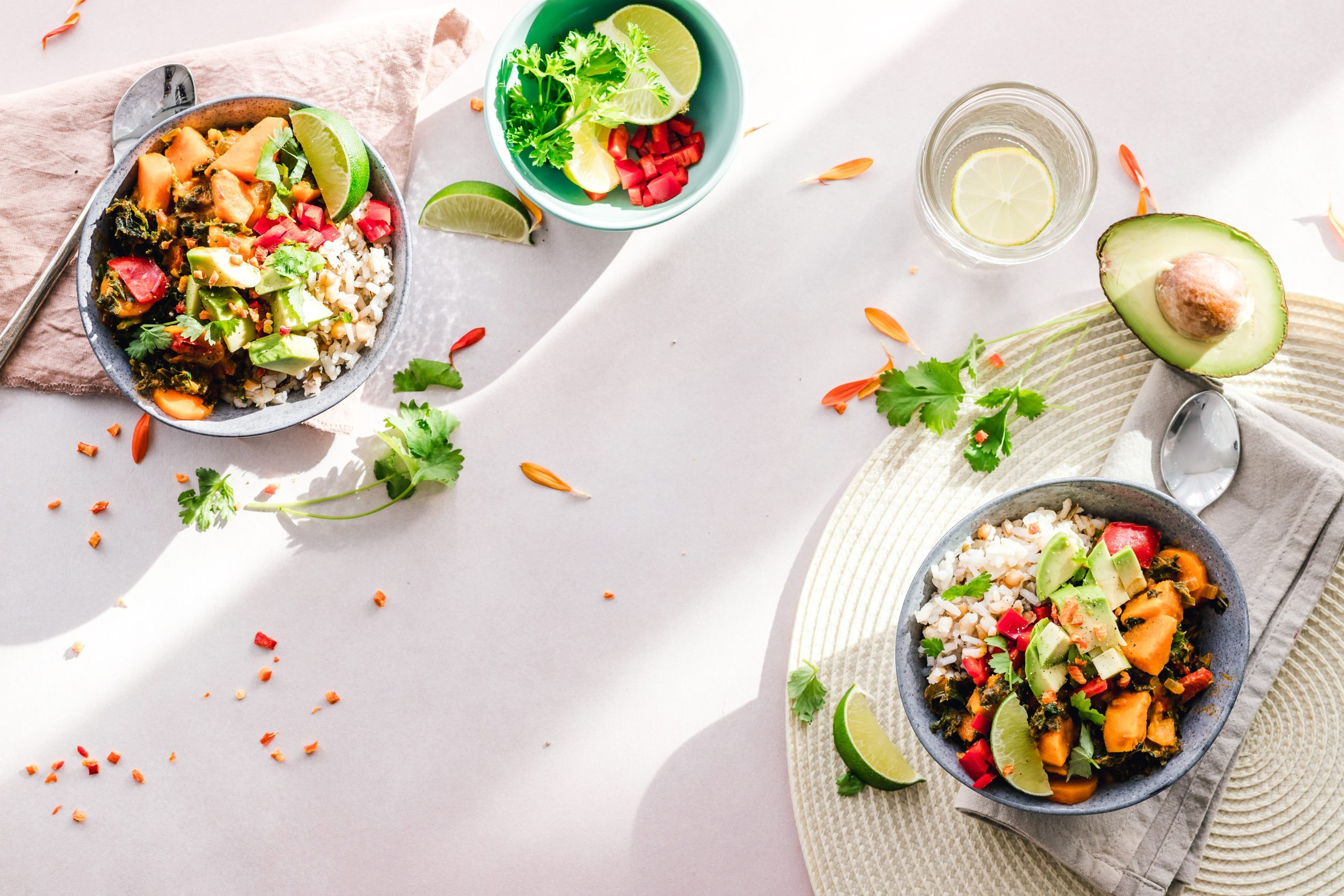 bowl of fruit & rice, glass of water and avocado on a table