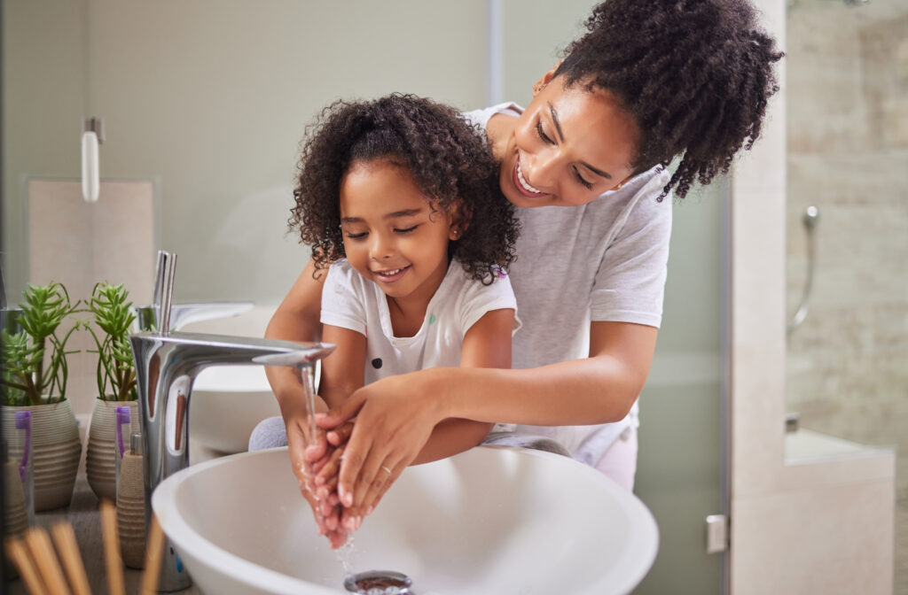 Child washing hands with mom.