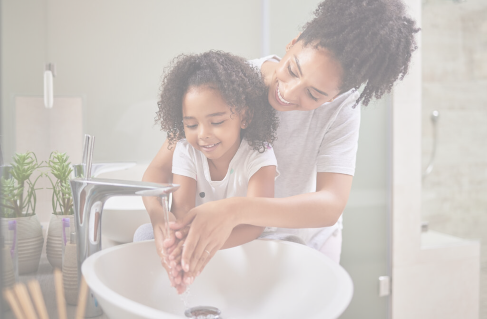 Mom helping to wash daughters hands.