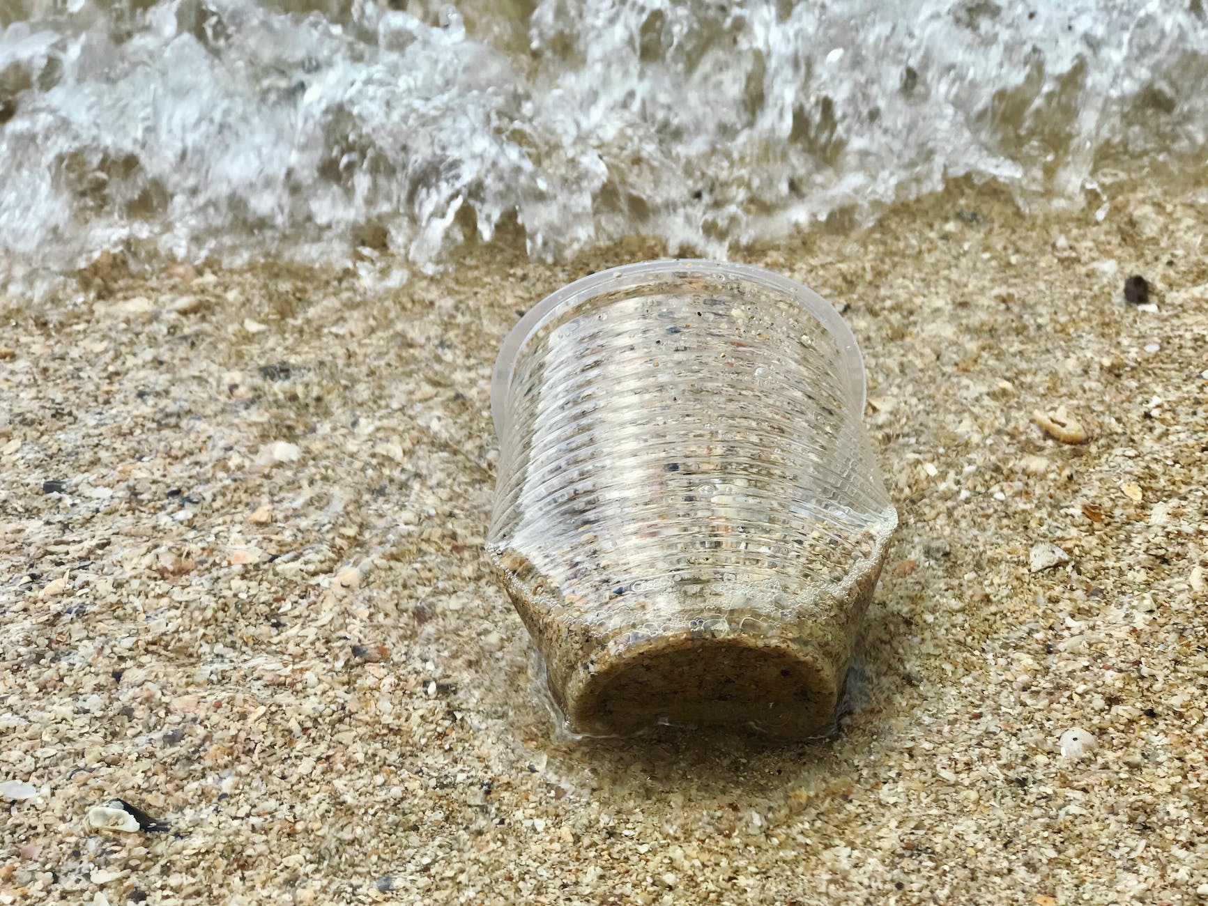 close up photo of plastic cup on sand