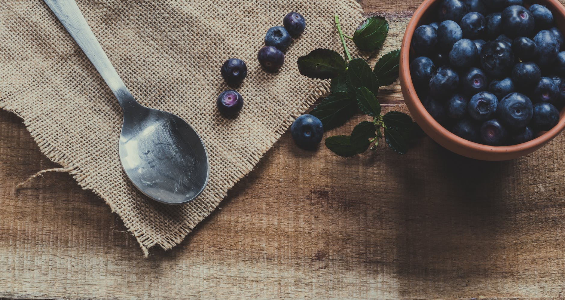 decorative, blueberries on mug and brown surface near spoon