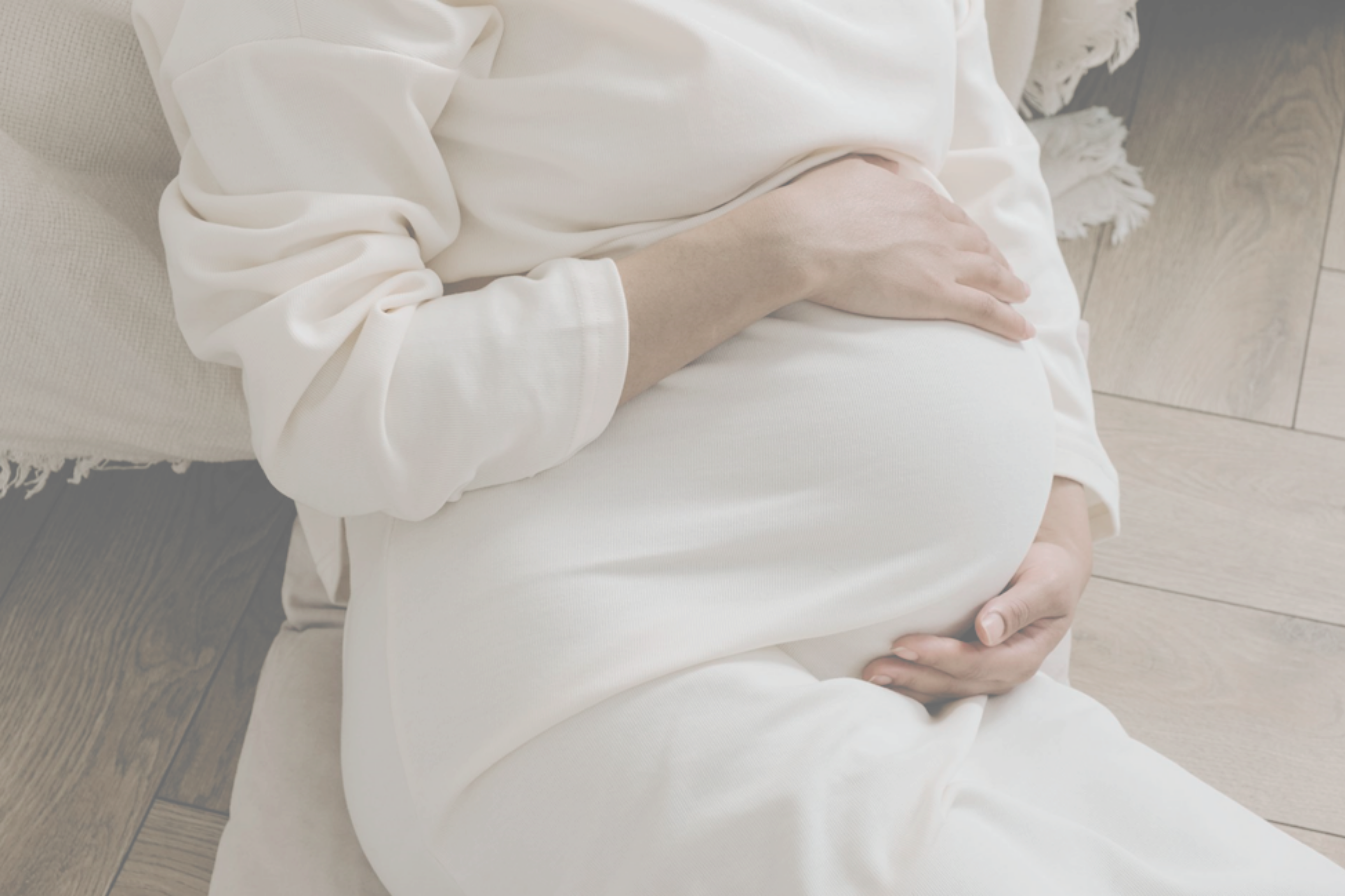 pregnant woman in white dress holding belly