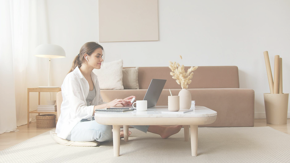 woman sitting on floor while working on her laptop