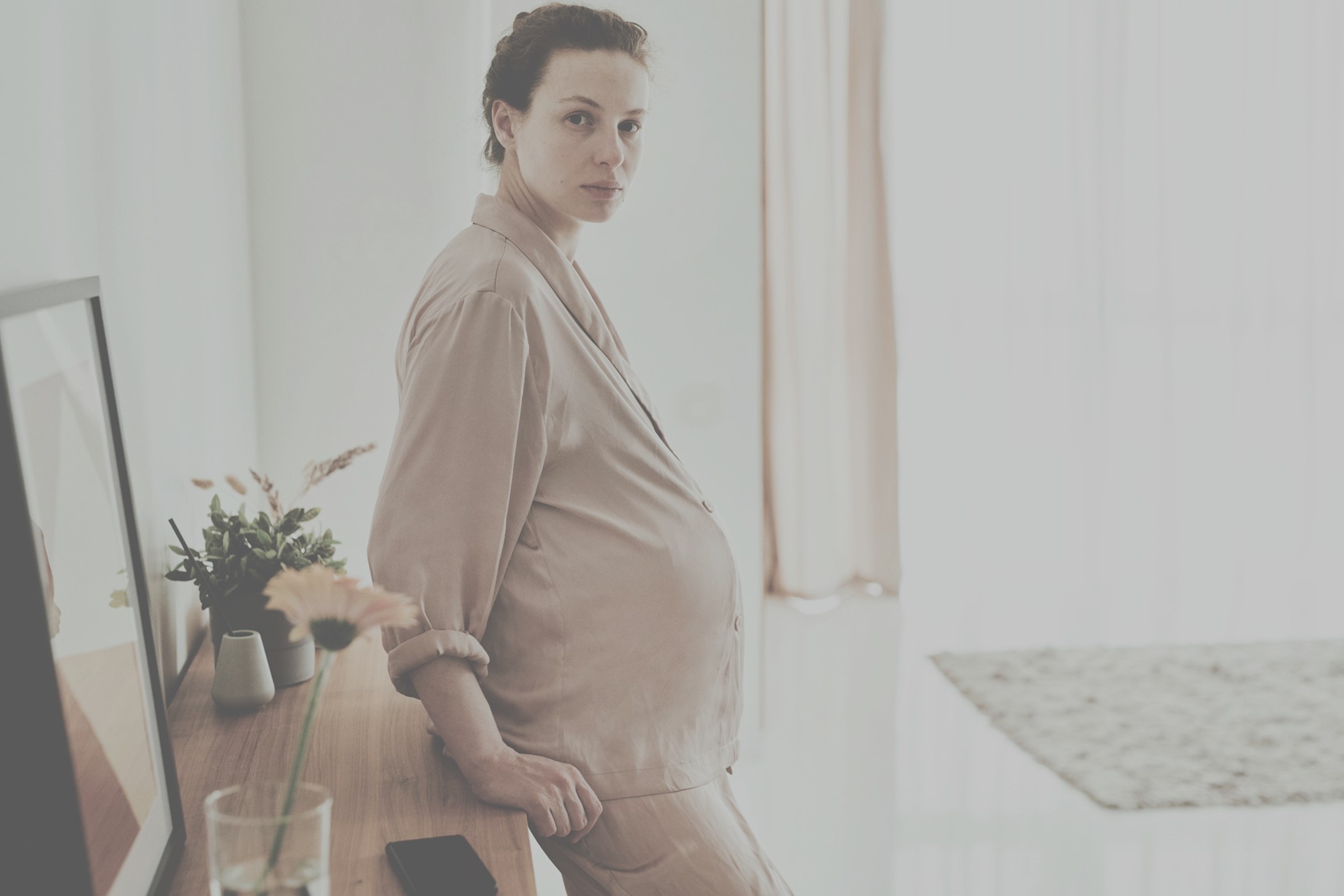 pregnant woman standing against table